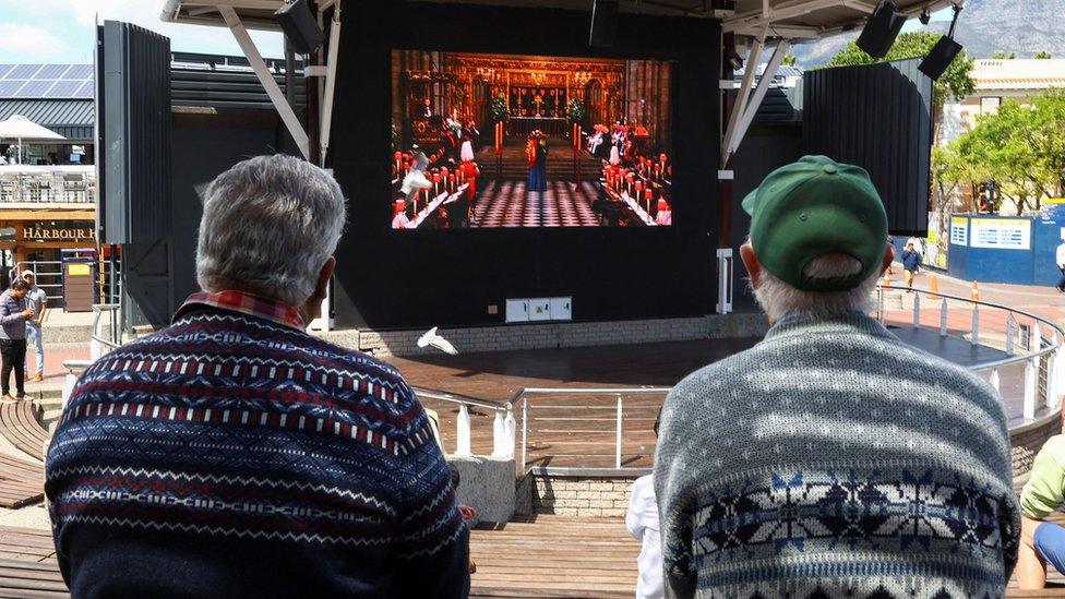 Spectators watch the service on a big screen in Cape Town