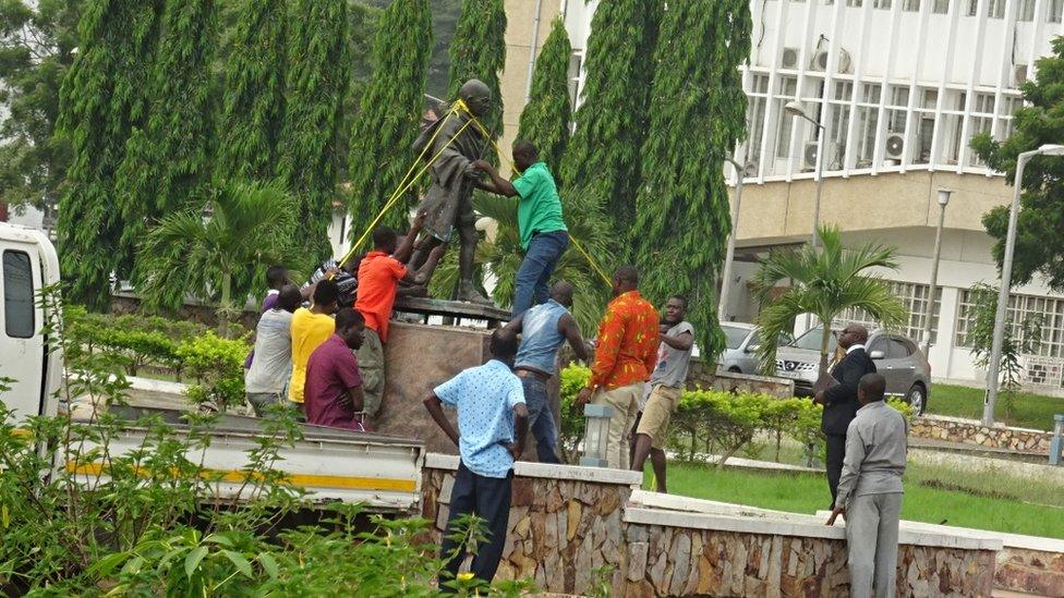 Men removing the Gandhi statue