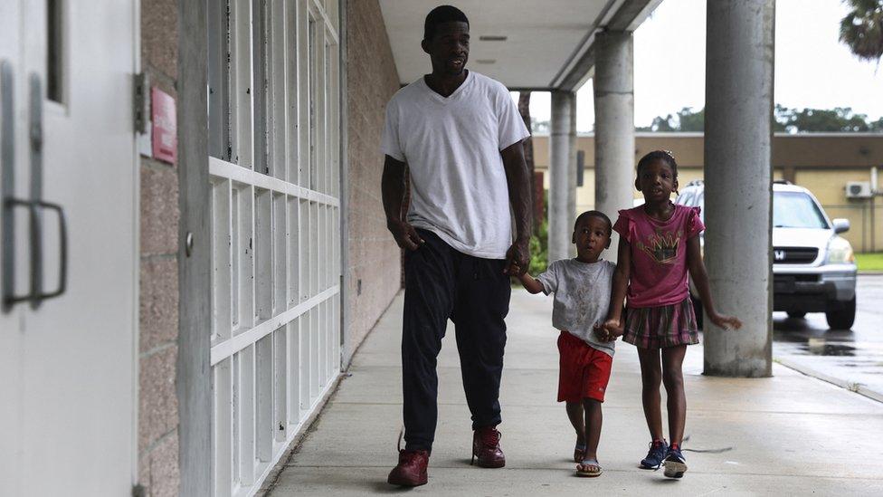 a man and two children walk towards a shelter