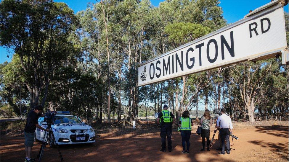 Media film a property from a police roadblock where police are investigating the deaths of seven people in suspected murder-suicide in Osmington, east of Margaret River, 260km south west of Perth, Australia, 11 May 2018.