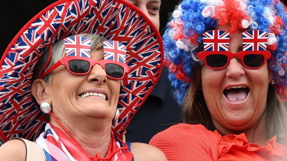 Women in Union flag colours watch the Twelfth parade in Belfast