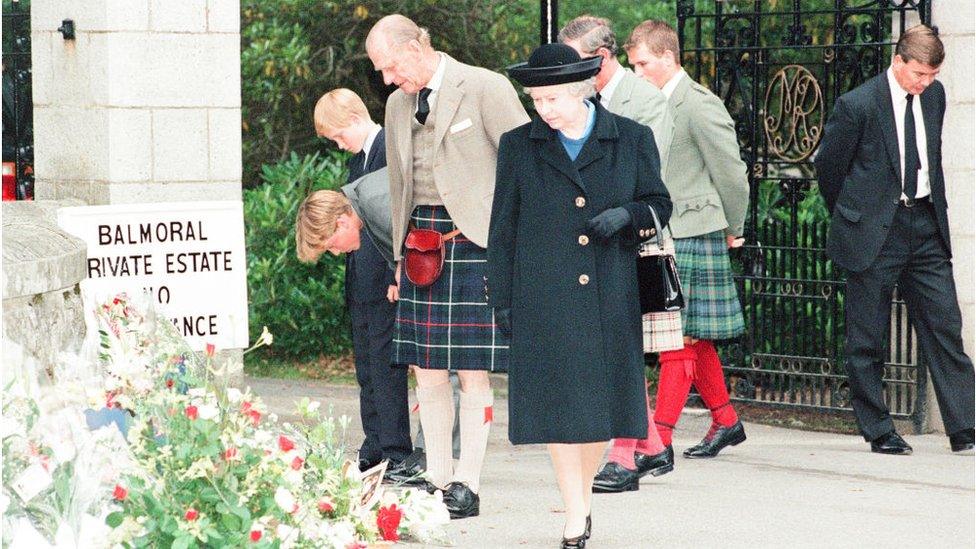 After attending a private service at Crathie Church, the royal family stop to look at floral tributes left for Princess Diana at the gates of Balmoral Castle