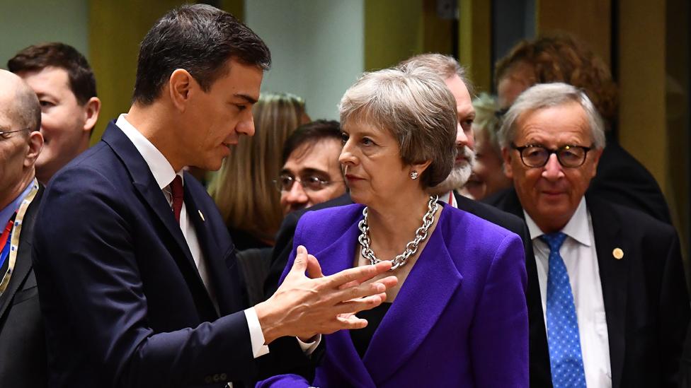 President of the European Commission Jean-Claude Juncker (R) looks on as Spanish Primer Minister Pedro Sanchez (L) and British Prime Minister Theresa May (C) talk as they attend the second day of an European Union leaders summit at the European Council in Brussels