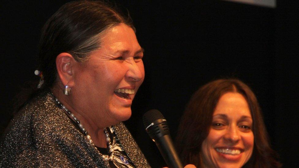 Activist Sacheen Littlefeather against a black background