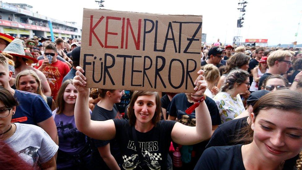 A festival goer holds up a sign that reads "no place for terror" at the Rock am Ring event in Germany (3 June 2017)