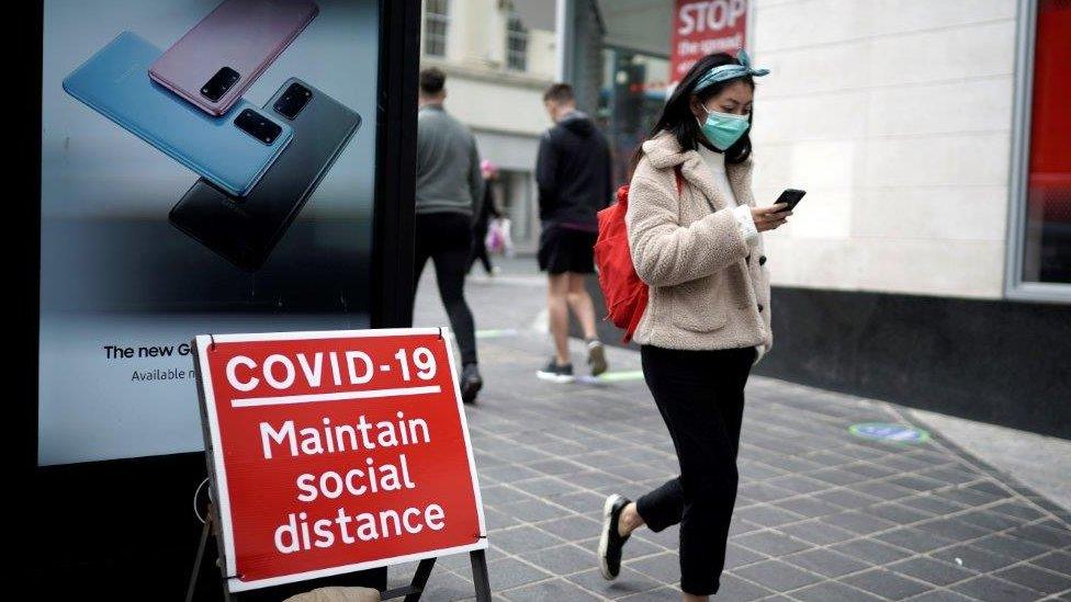 A woman wears a face mask on the high street on July 14, 2020