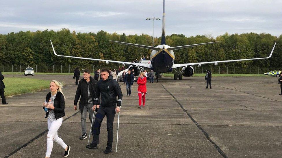 Passengers leave the plane that was escorted to Stansted