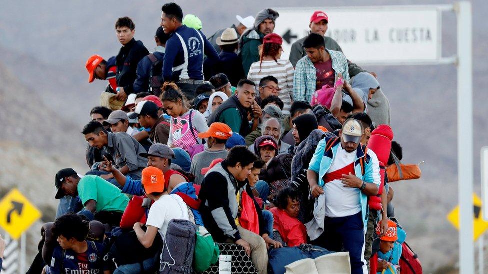 Migrants, part of a caravan of thousands travelling from Central America to the US, sit on the back of a truck en route to the Mexican border city of Tijuana, 20 November 2018