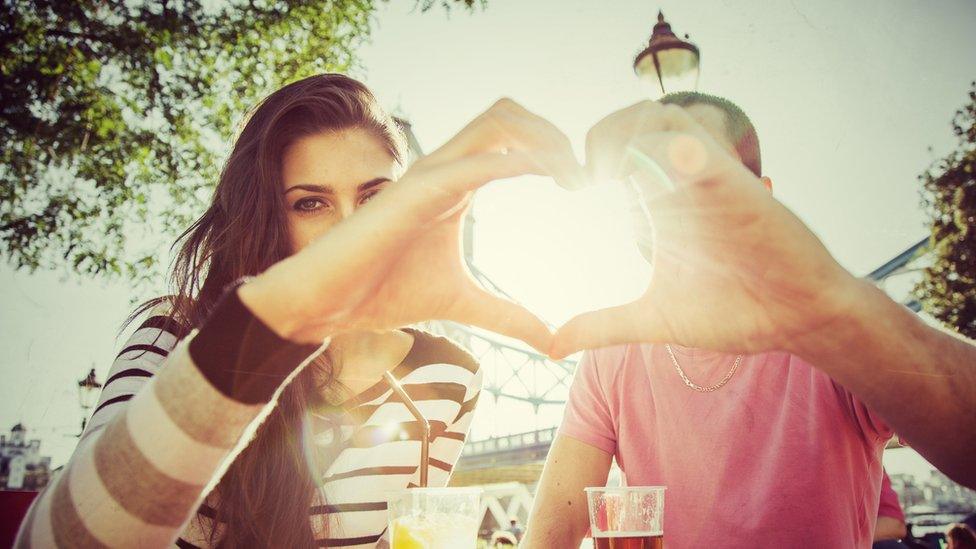 couple making a heart shape with their hands