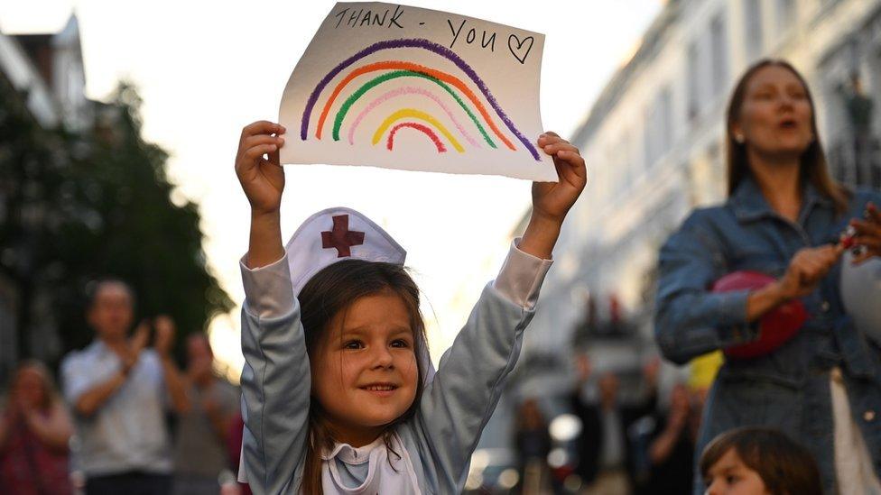 Girl in nurse costume holds up sign saying "Thank you"