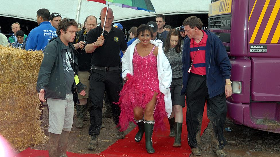 Shirley Bassey yn cerdded yn ei wellingtons