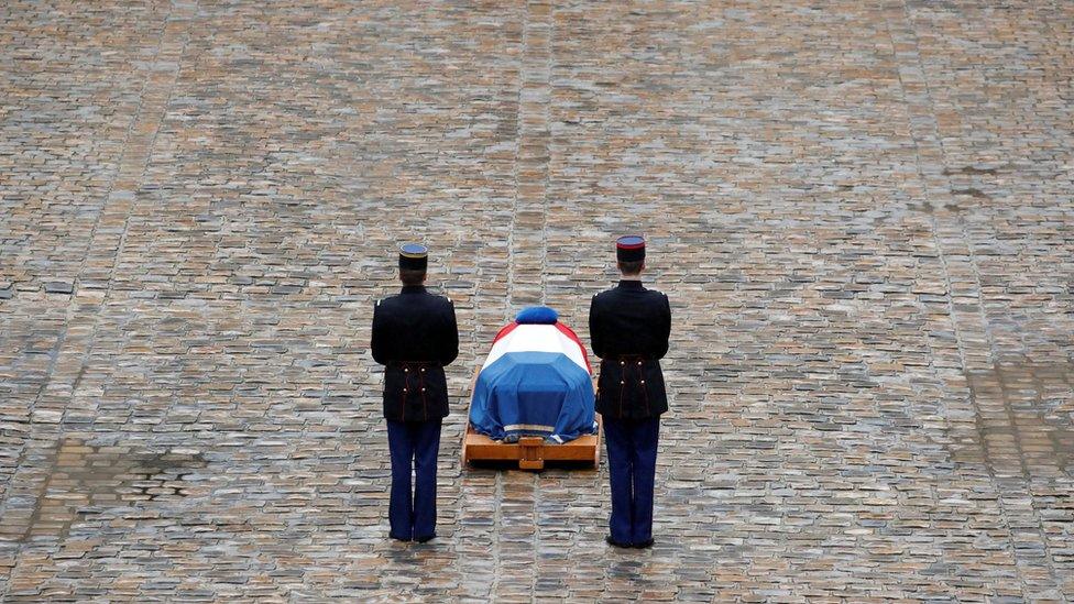 French Republican guards stand in front of the flag-draped coffin of late Gendarmerie officer Colonel Arnaud Beltrame