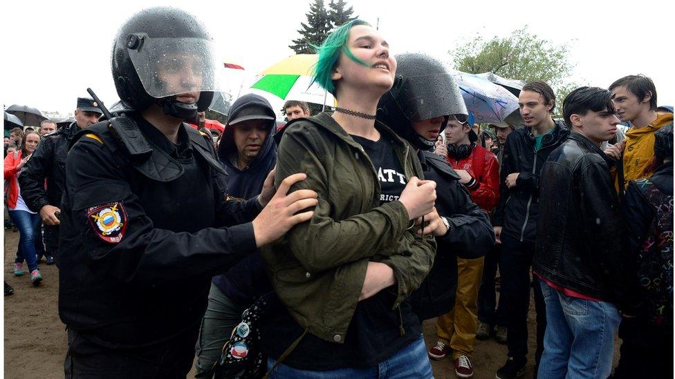 Russian police officers detain a young woman participating in an unauthorised opposition rally in centre of Saint Petersburg on June 12, 2017