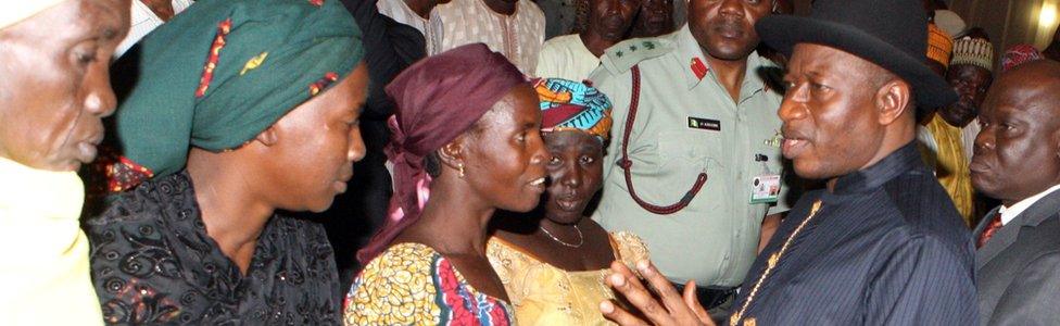 Goodluck Jonathan (R) speaks to relatives of some of the Chibok schoolgirls who escaped their Islamist captors.