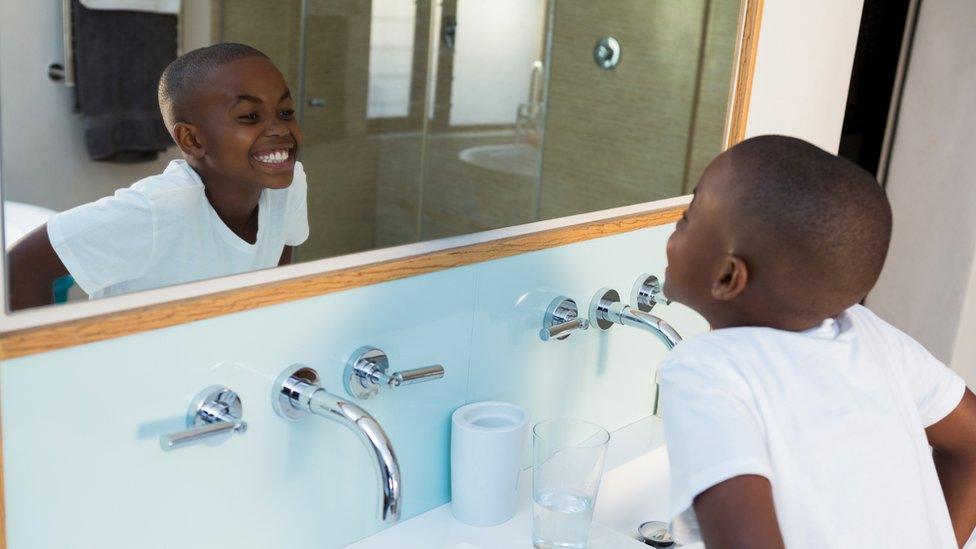 Boy grinning in the mirror