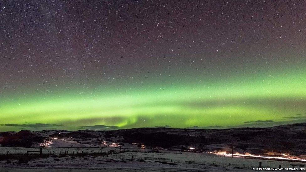 Green glow from Northern Lights over snowscape