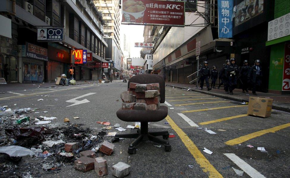 Chair in deserted street, with bricks stacked up on top