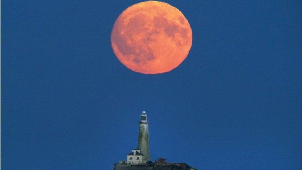 Buck Moon rising over St Mary's Lighthouse in Whitley Bay on the north-east coast of England