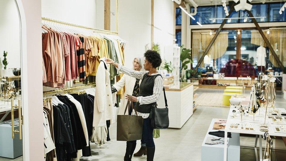 Stock photo of women looking at coats while shopping