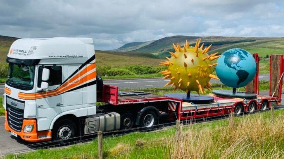 Truck with sun and earth on back of lorry