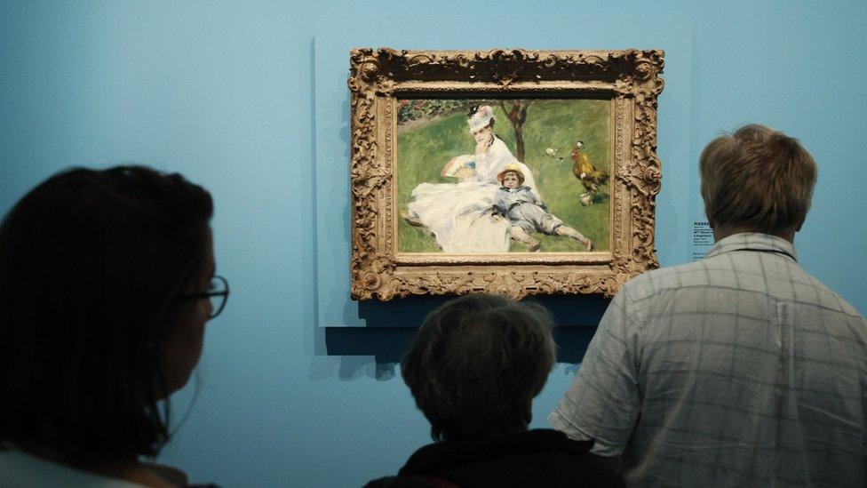 Visitors look at a painting entitled "Madame Monet et son fils Jean dans le jardin a Argenteuil" (Camille Monet and Her Son Jean in the Garden at Argenteuil) by French artist Pierre Auguste Renoir during the exhibition "Monet Collector. Masterpieces from His Collection" at the Marmottan Monet Museum in Paris, France, 14 September 2017.