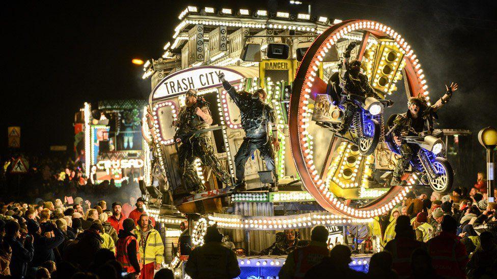 Illuminated cart with "Trash City" sign