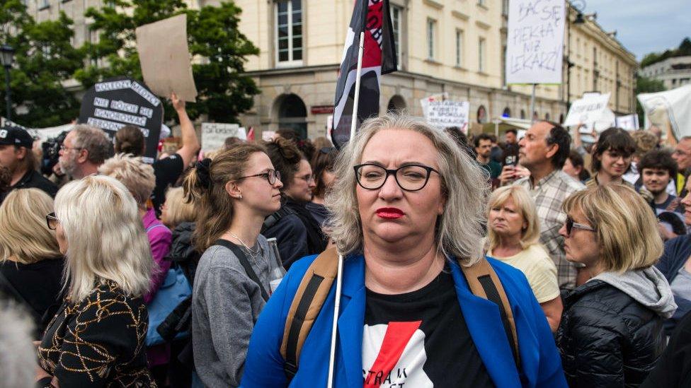 Marta Lempart, the leader of the Women's Strike organisation stands in the middle of demonstration surrounded by dozens of protesters in June 2023.