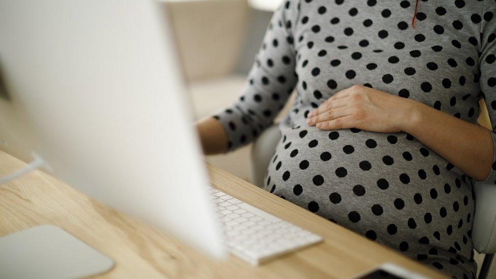 Pregnant woman at computer