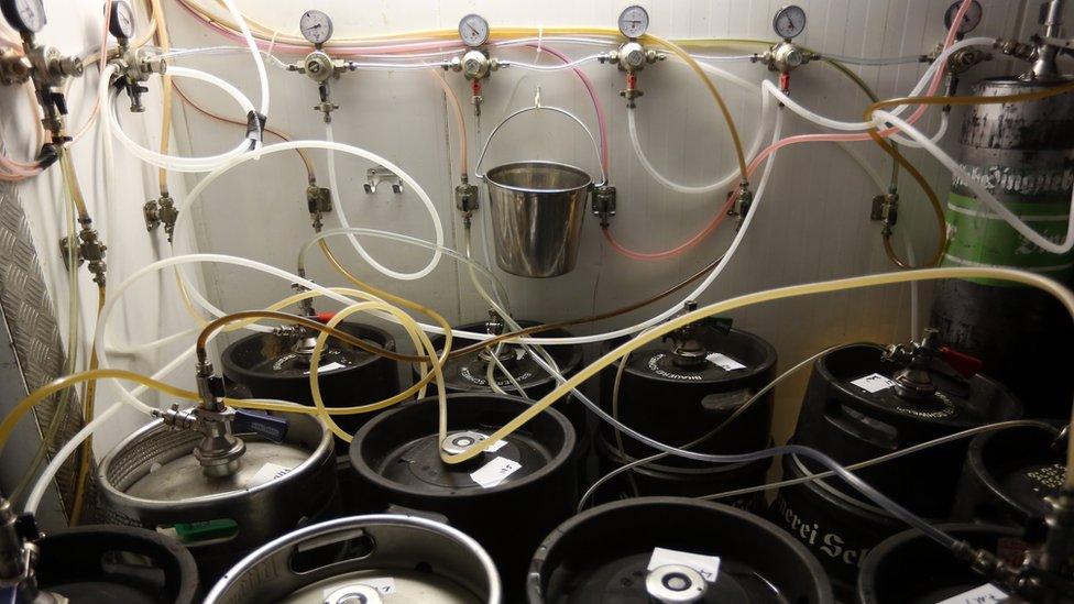 Tubes leading upstairs to beer taps are seen connected to kegs of beer in the cellar at Hops & Barley brewery on November 12, 2013 in Berlin, Germany.