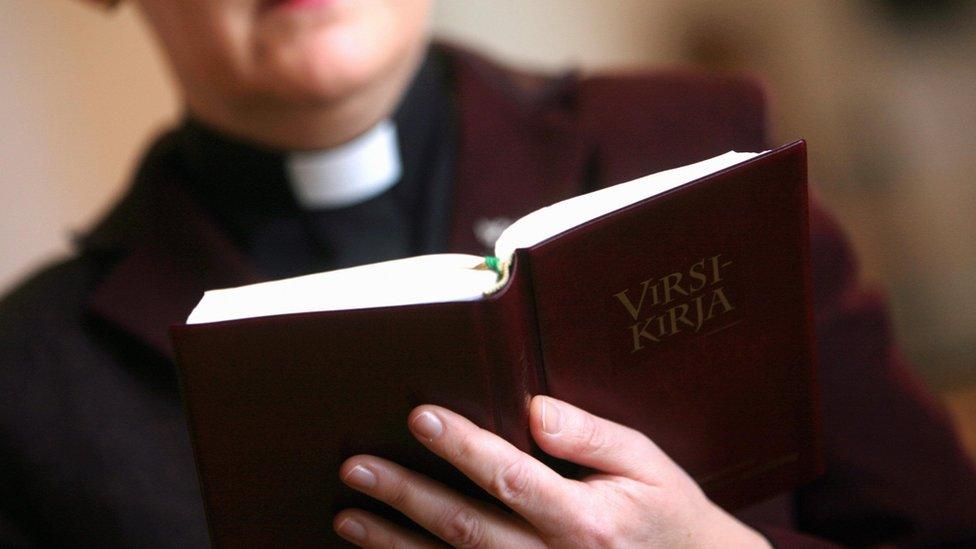 This picture taken 31 January 2007 shows Lutheran female minister Leena Salmensaari with a psalm book in Kirkkonummi church, outside Helsinki, Finland.