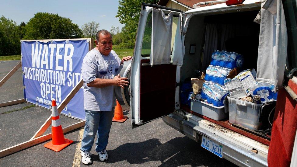 Raul Garcia Jr., loads water into a van at Our Lady of Guadalupe Church in Flint