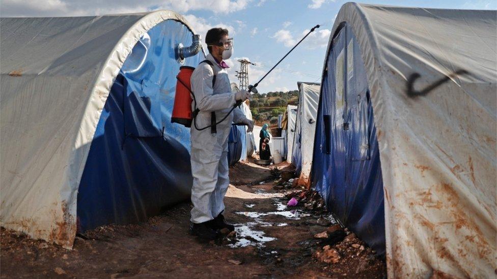 A member of the Syrian Violet NGO disinfects tents at a camp for displaced people in Kafr Jalis village, north of Idlib city, on March 21, 2020