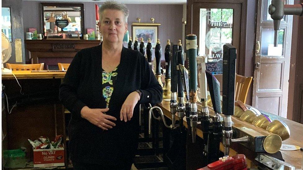 A pub landlady behind the bar