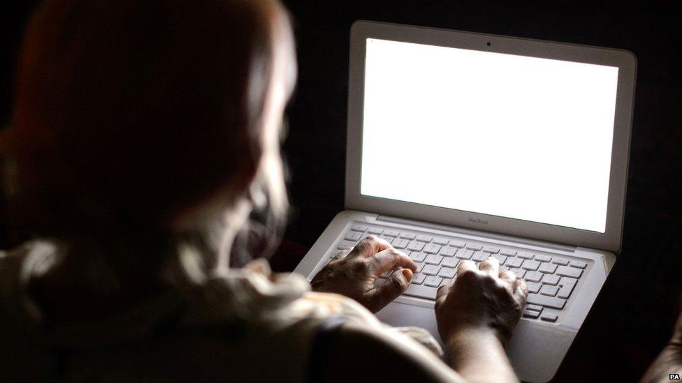 Person using a laptop in the dark