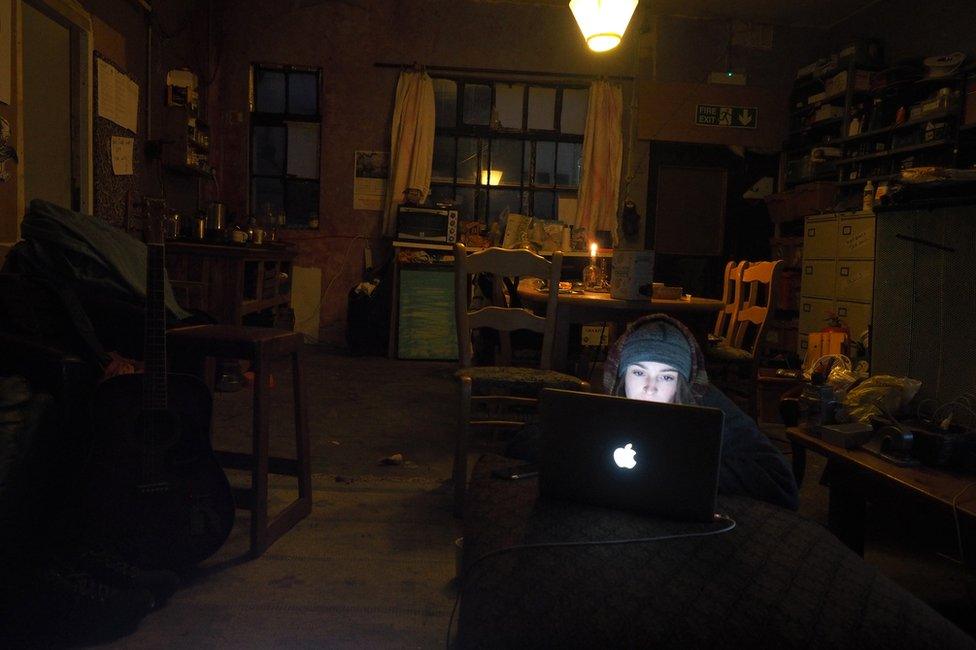 A woman using a laptop in a darkened room