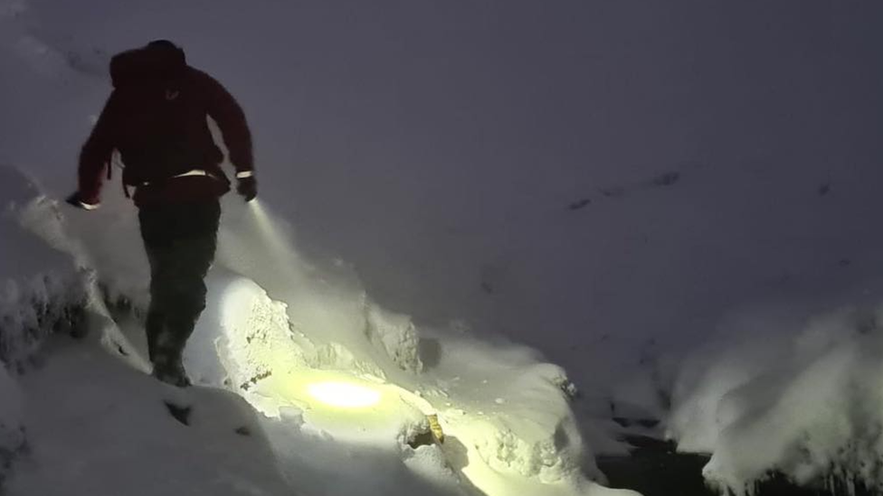 Rescuer walks through snow