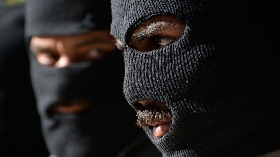 Taliban militants wearing balaclavas at a police headquarters in Jalalabad in March