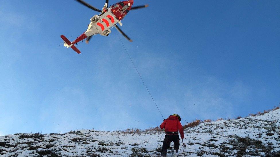 A Brecon MRT mountaineer and a rescue helicopter