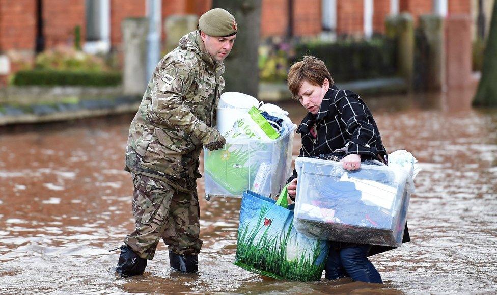 Woman being helped in flood