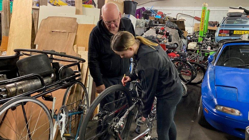 Paiton gets to grips with a bicycle in need of repair