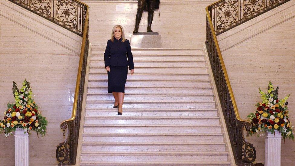 Michelle O'Neill walks down white staircase in Stormont