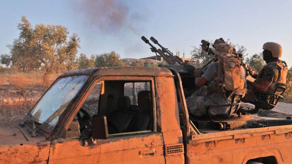 Hayat Tahrir al-Sham (HTS) fighters fire an anti-aircraft weapon in southern Idlib province (7 August 2019)