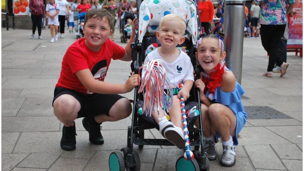 Cameron, 8, Harry, 2, and Sasha, 10 watch the parade