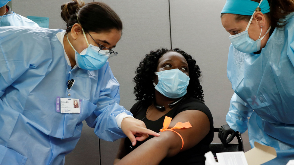 Nurses take blood from the arm of a woman