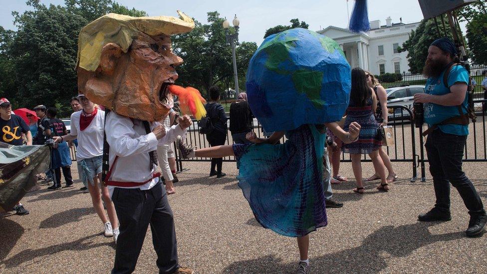 Protesters wearing a mask of US President Donald Trump and one of the Earth pretend to fight in front of the White House during the People's Climate March in Washington, DC, on April 29, 2017