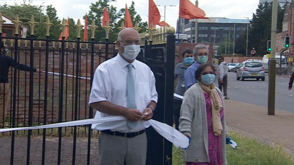 People standing around Gandhi statue