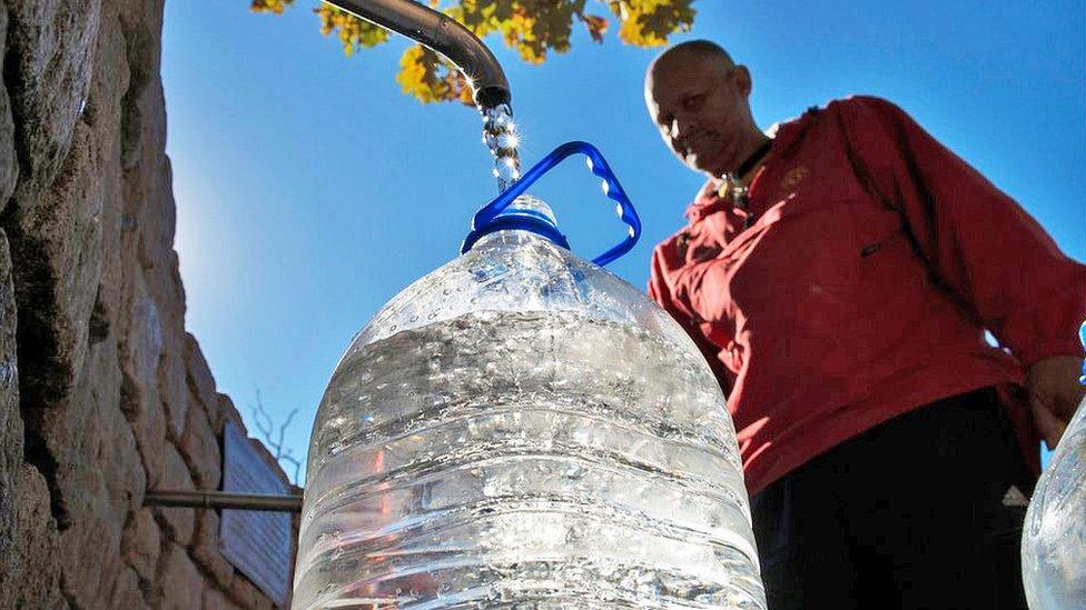 Man filling water flagon from tap