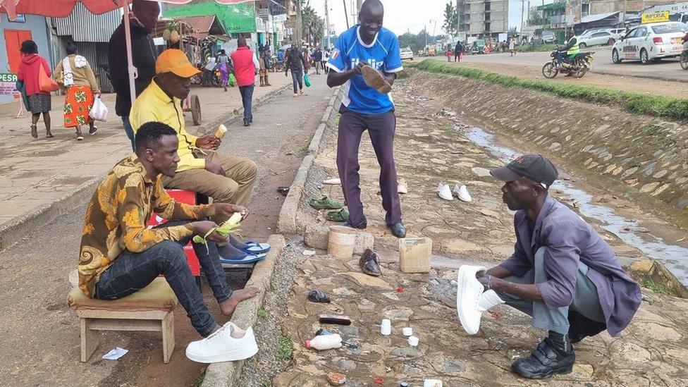 Kakamega senatorial aspirant Boni Khalwale (in yellow) eating roasted maize