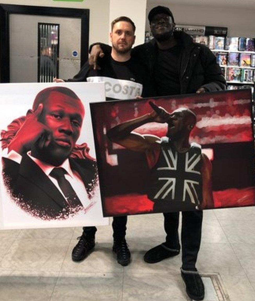 John Donaldson presenting Stormzy with pictures he had drawn of the musician