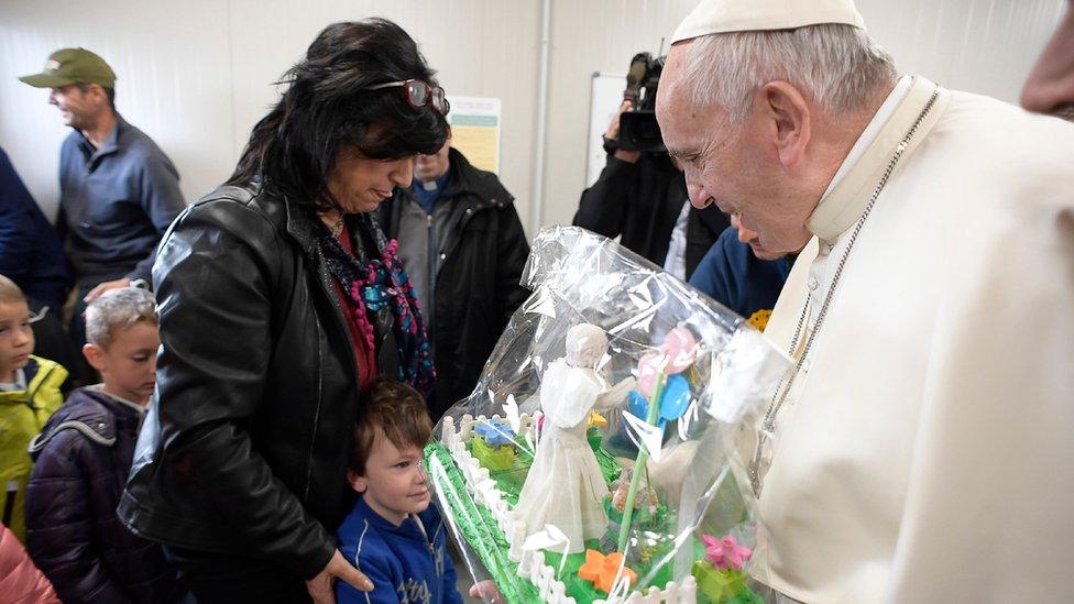 Pope Francis is given a gift during his visit to the school of the quake-struck town of Amatrice, Italy, 4 October 2016